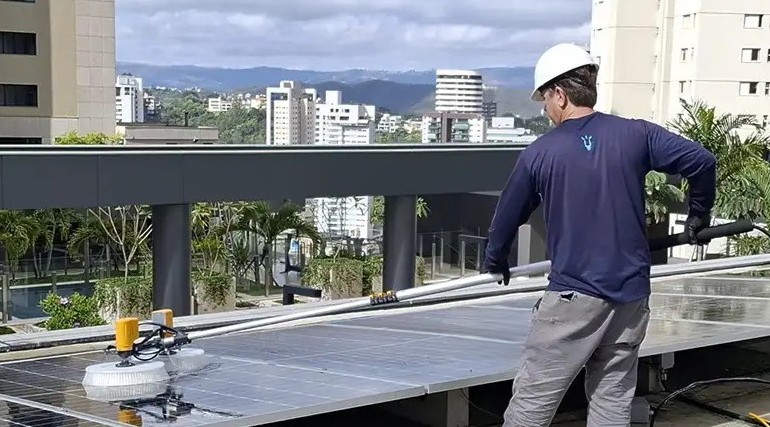 Profissional realizando limpeza de painéis solares